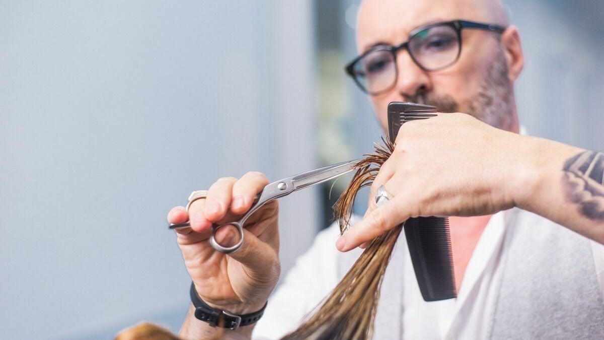 Estilista cortando cabello con tijera
